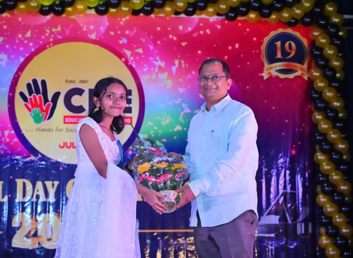 A CPE student welcoming a guest with a bouquet at the 19th Annual Day celebrations