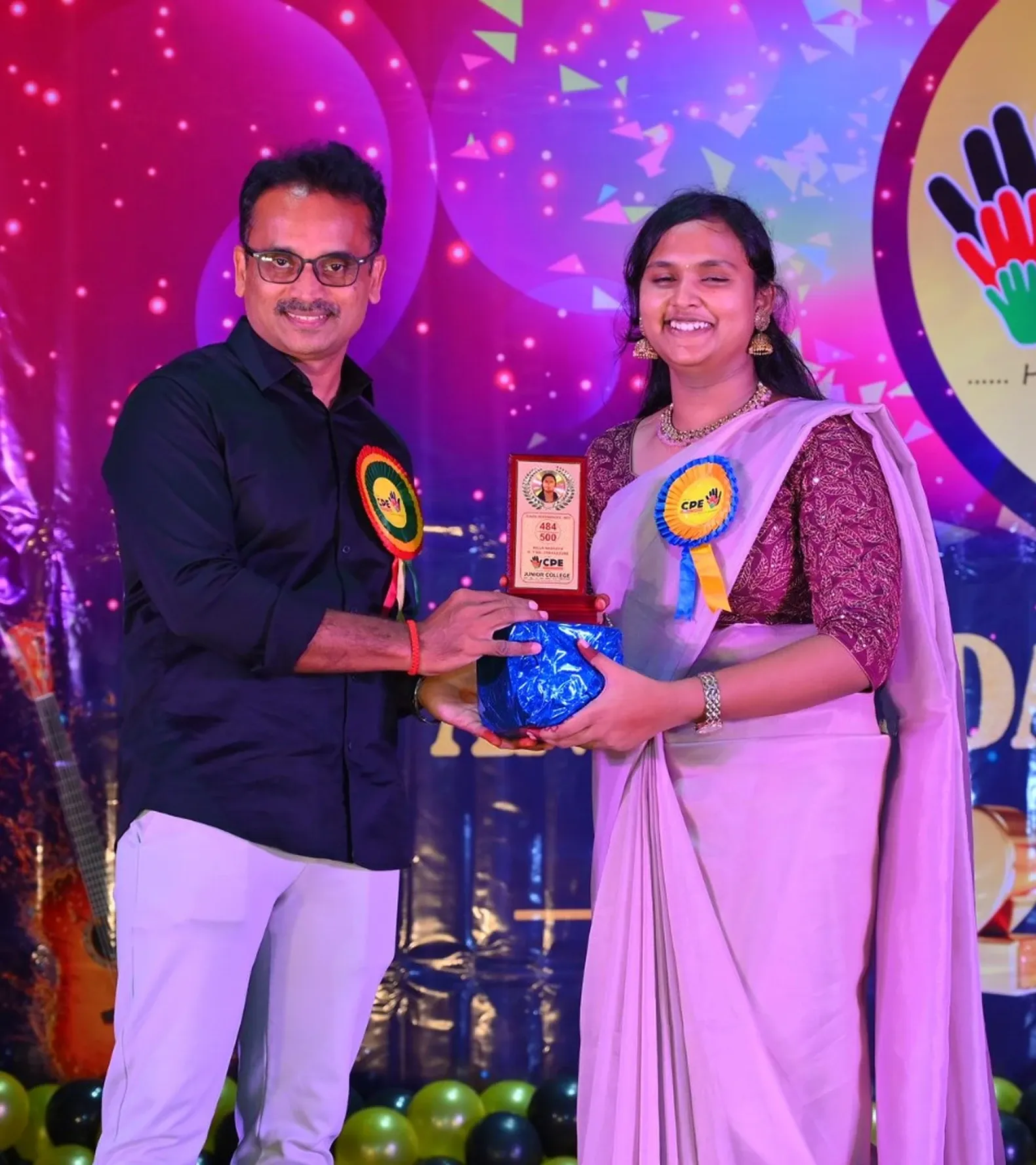 A student receiving an academic achievement memento and gift